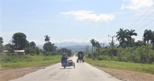 Motorcycle with sidecar and horse carriage on a Cuban road