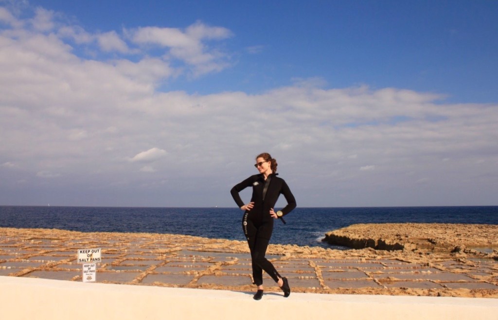 Girl in wetsuit in front of the salt pans near Marsalforn Gozo