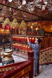 Caretaker hanging up incense coils in Man Mo Temple Hong Kong