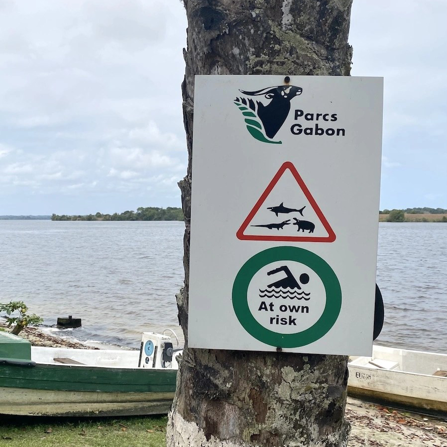 Warning sign for sharks crocodiles and hippos: swim at own risk, Gabon National Parks